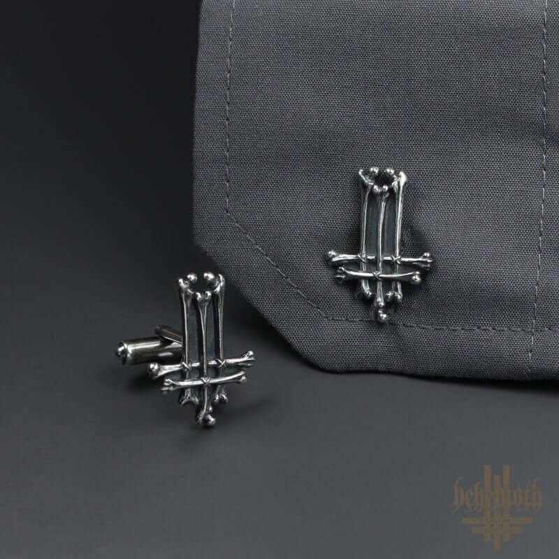 Behemoth 'Trivmviratvs' sterling silver cufflinks with dark, hand-sculpted details showcased on a grey fabric background.