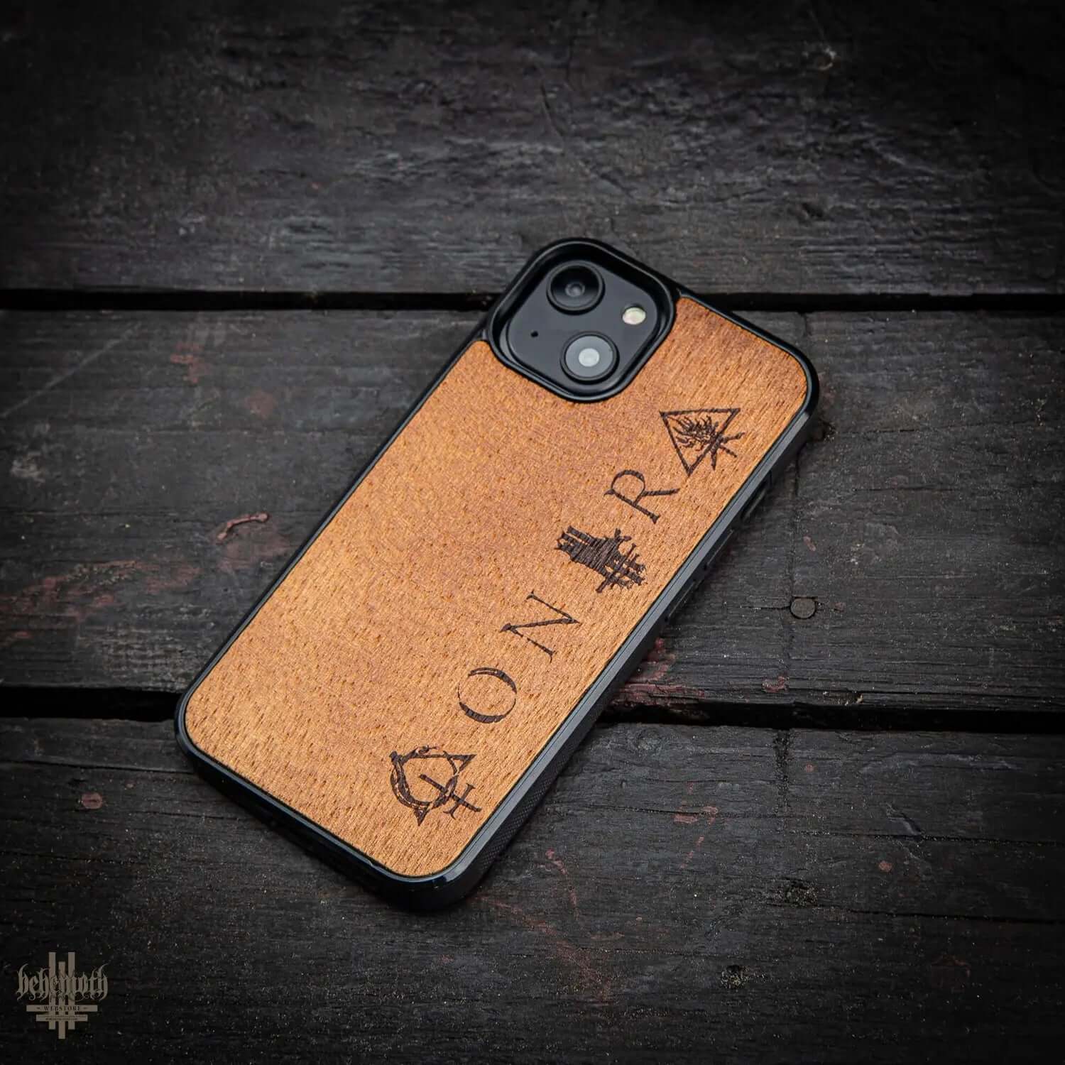 iPhone 14 case with merbau wood finish and Behemoth 'CONTRA' logo, handcrafted in Poland, offering unique style and durability.