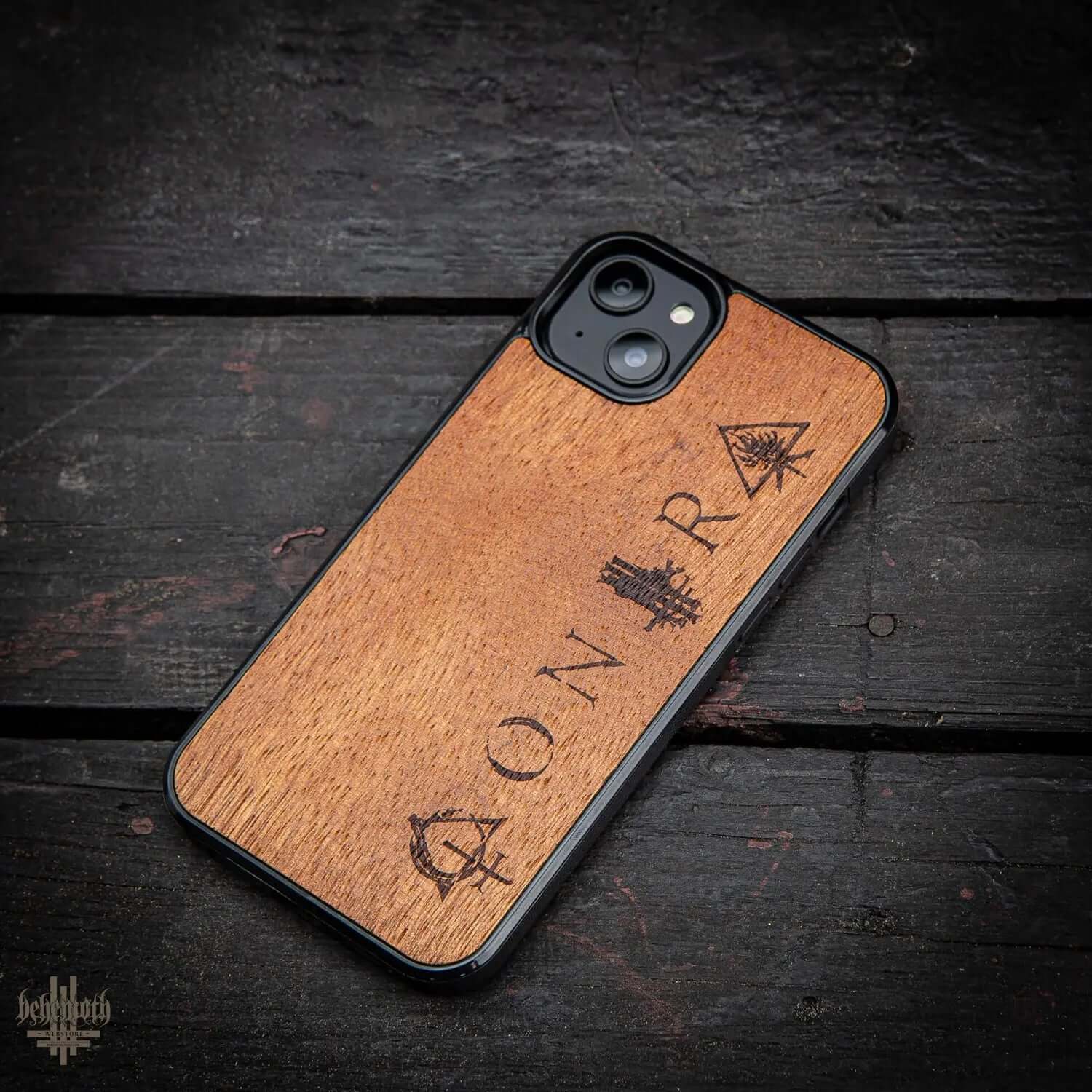 iPhone 14 Plus case with wood finish and 'CONTRA' logo on dark surface, made of exotic merbau and polycarbonate, hand-finished in Poland