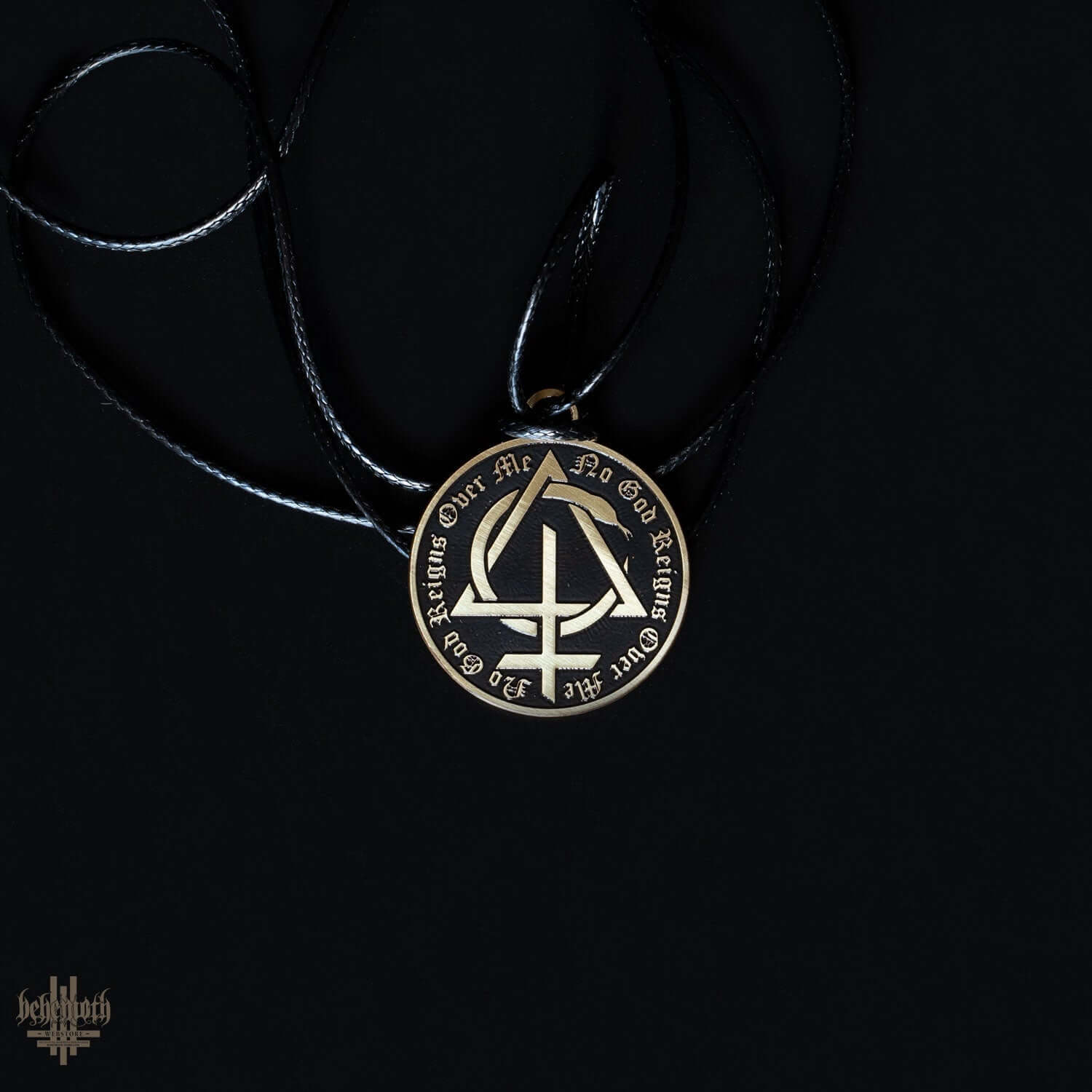 Behemoth CONTRA 'No God Reigns Over Me' brass necklace with black strap on dark background.