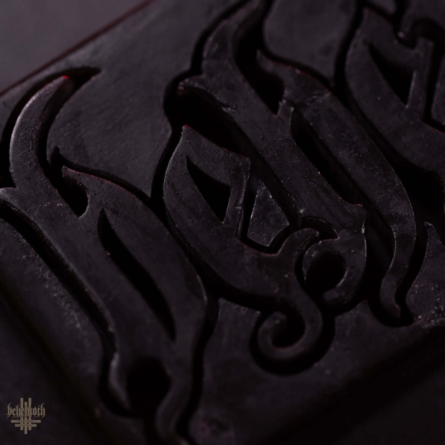 Close-up of black organic glycerine soap bar with carved Behemoth logo.