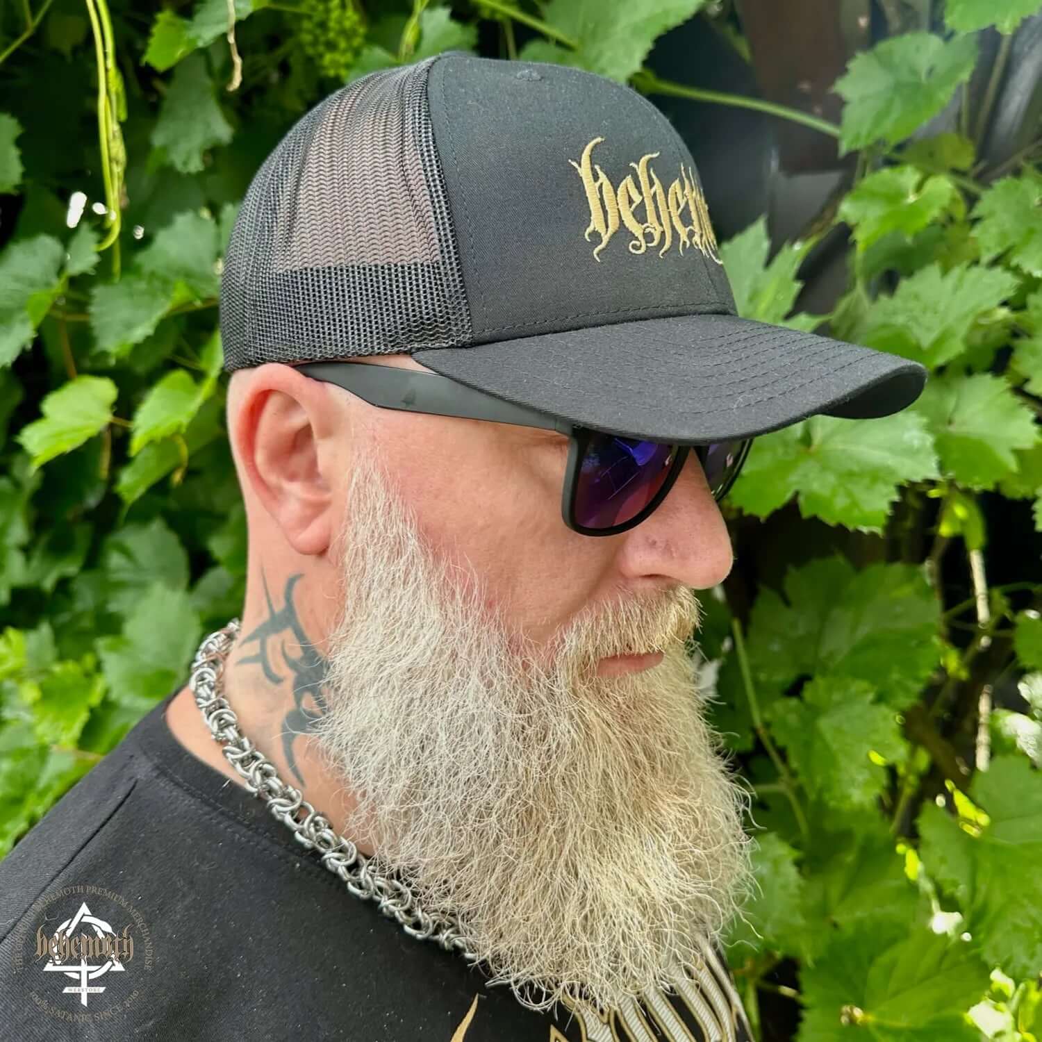 Man wearing Behemoth embroidered logo classic trucker cap outdoors