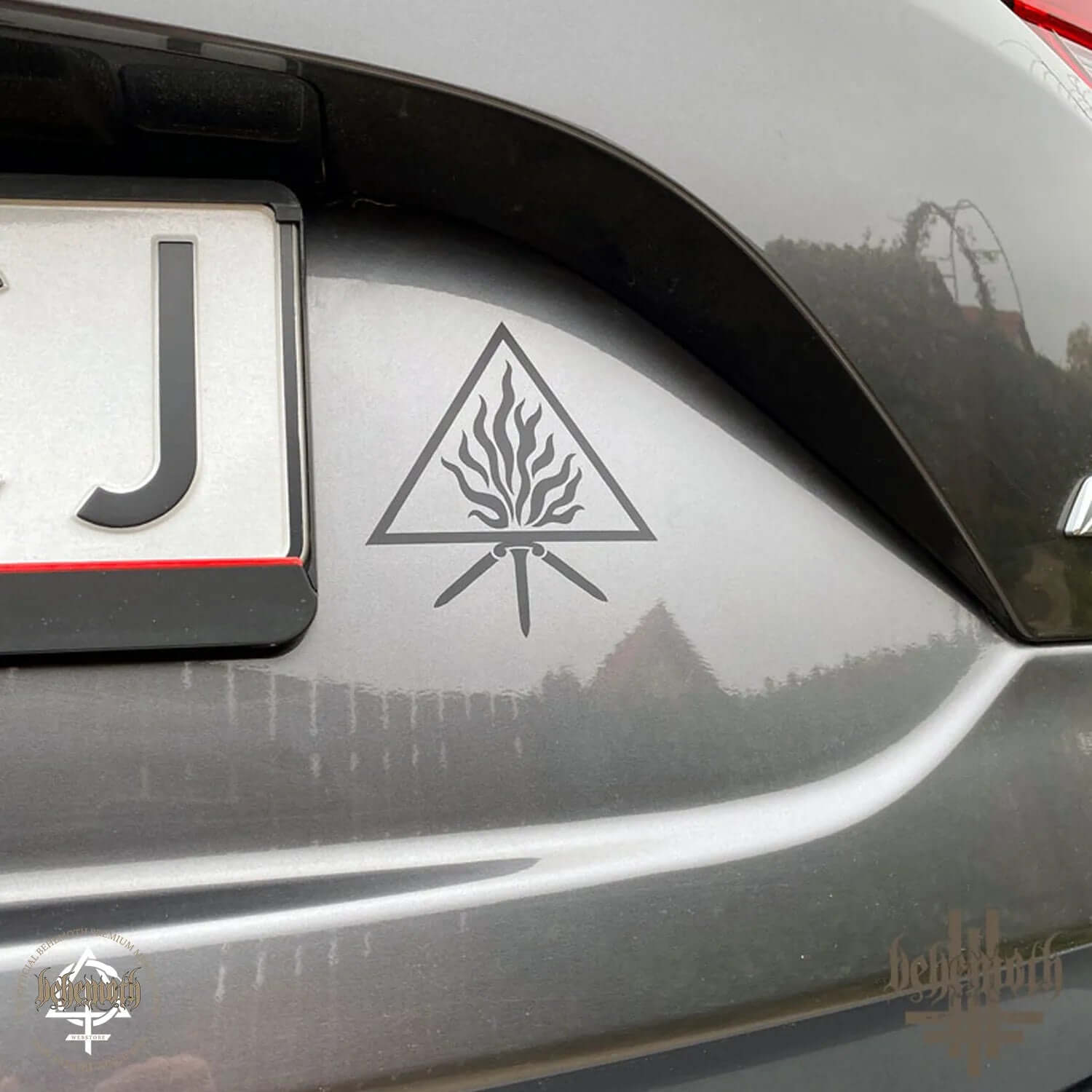 Black matte vinyl sticker 'The Unholy Trinity' design on car body from Behemoth Webstore, measures 10 cm in diameter.