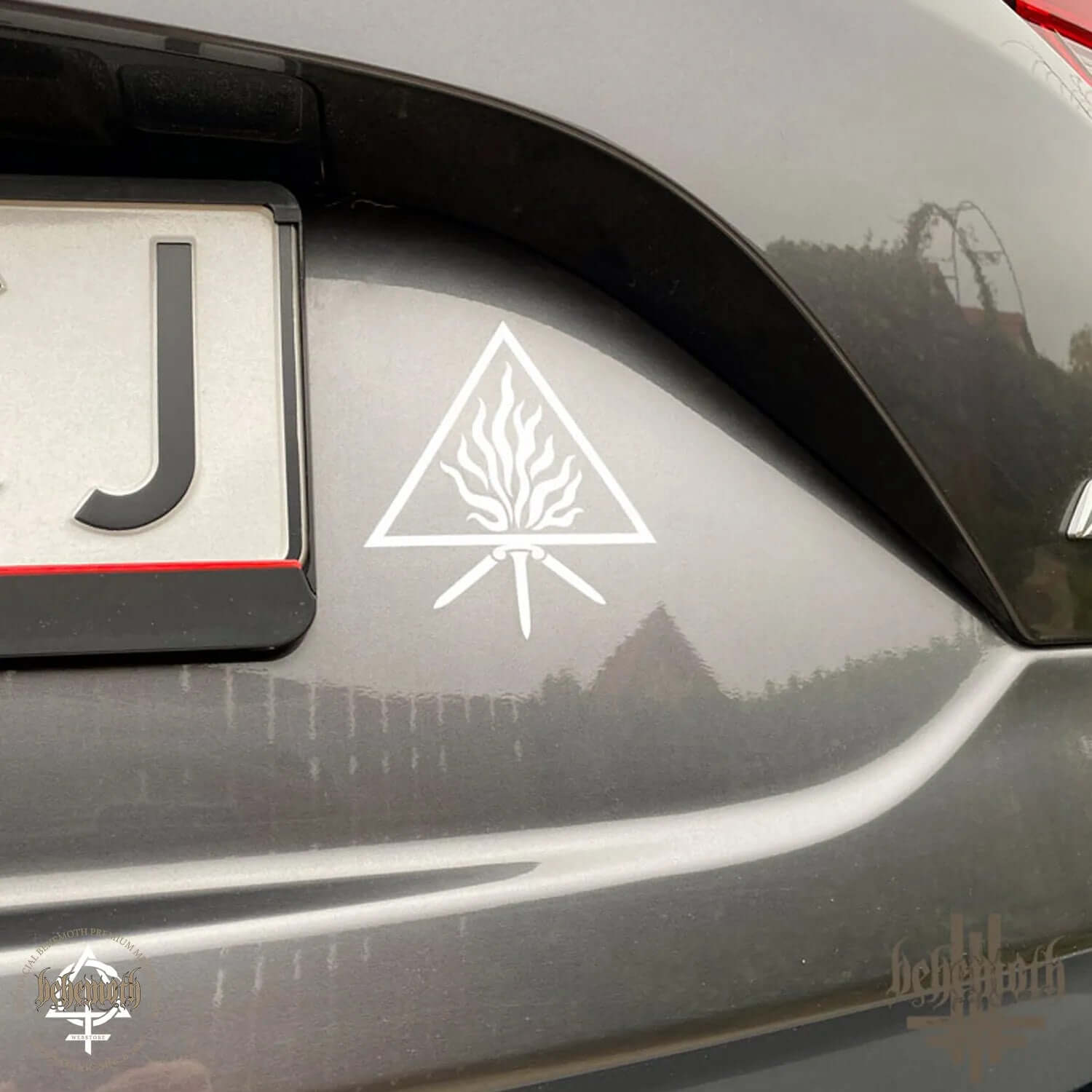 White vinyl sticker with 'The Unholy Trinity' design on car body, Behemoth decal, matte finish, 10 cm diameter.