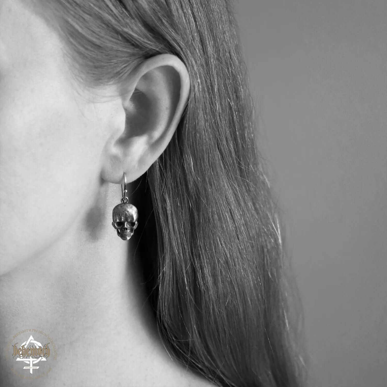Woman wearing a Behemoth 'Contra Skull' sterling silver earring, handcrafted using the lost wax technique, showcasing intricate details.