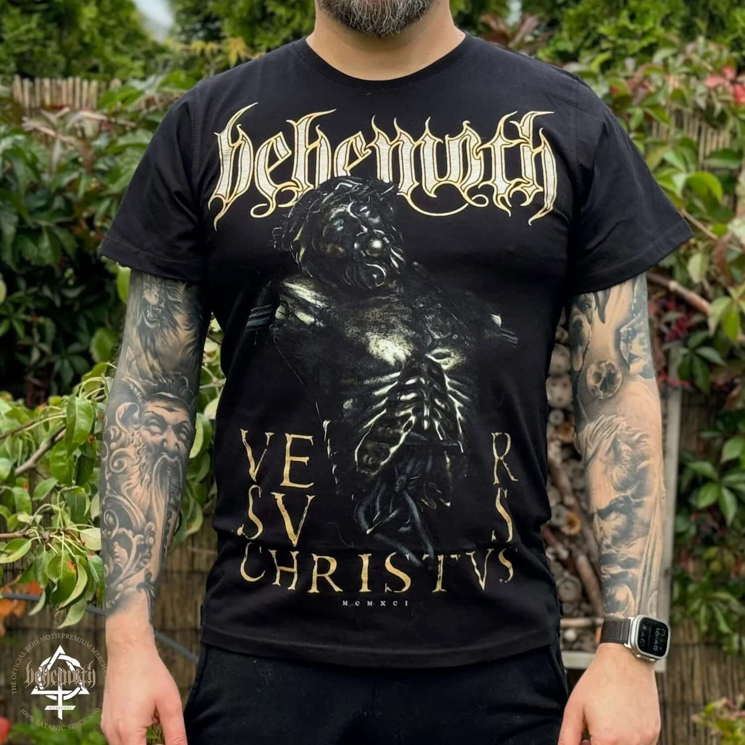 Unisex 'Versvs Christvs' Behemoth T-shirt with front print, modeled outdoors, showcasing tattooed arms.