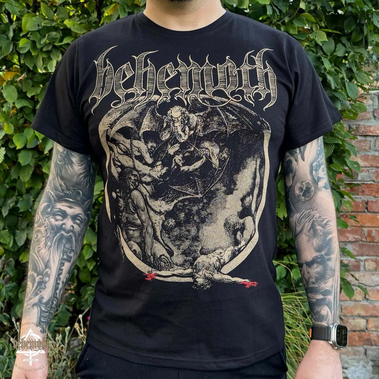 Unisex 'Crucifixion Was Not Enough' Behemoth T-shirt with front graphic, worn by tattooed model, outdoor setting.