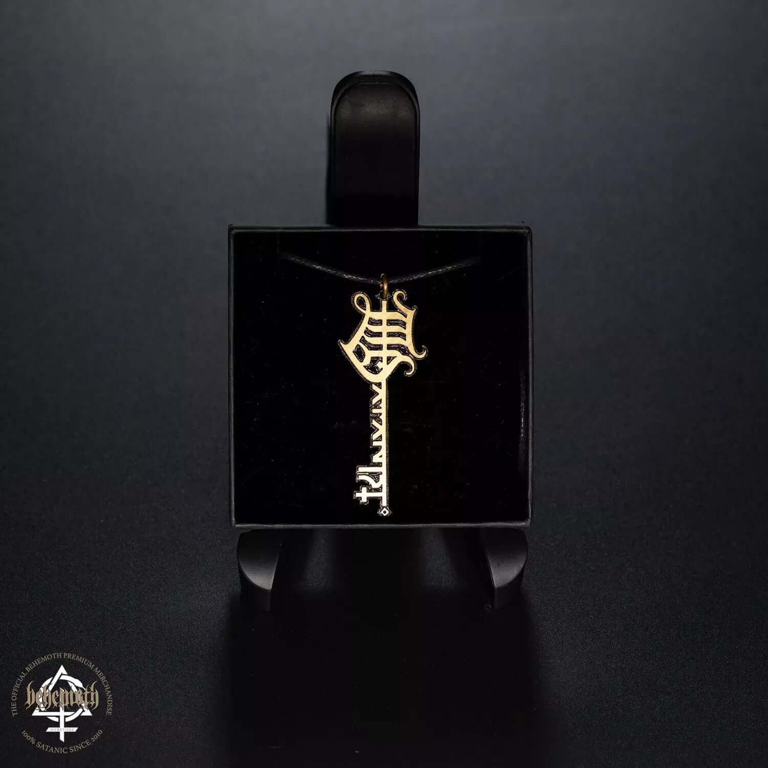 Behemoth 'The Satanist' brass necklace with patinated finish, featuring a dark display stand against a black background.