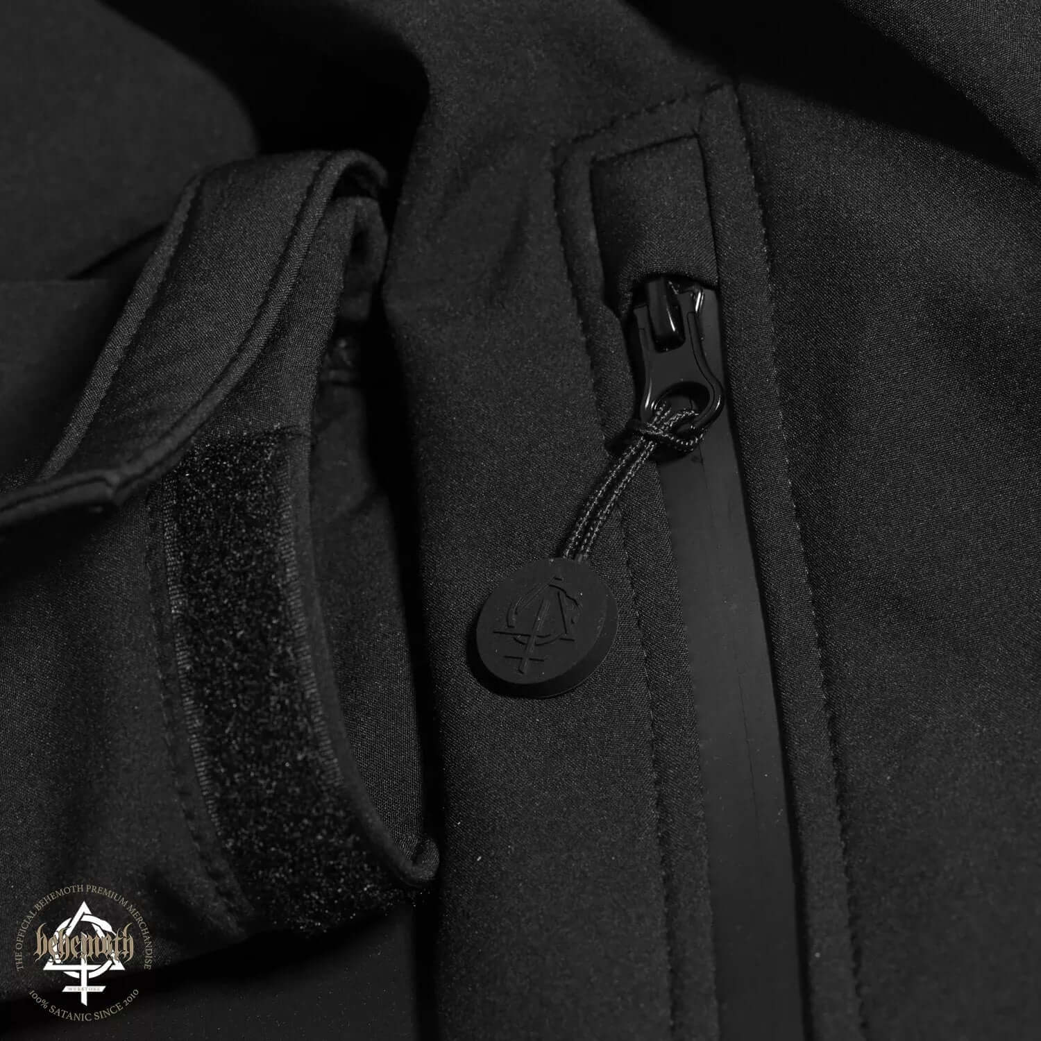 Close-up of Behemoth Logo Softshell Jacket, featuring black zip puller and velcro cuff, from Blackest Ov The Black collection.