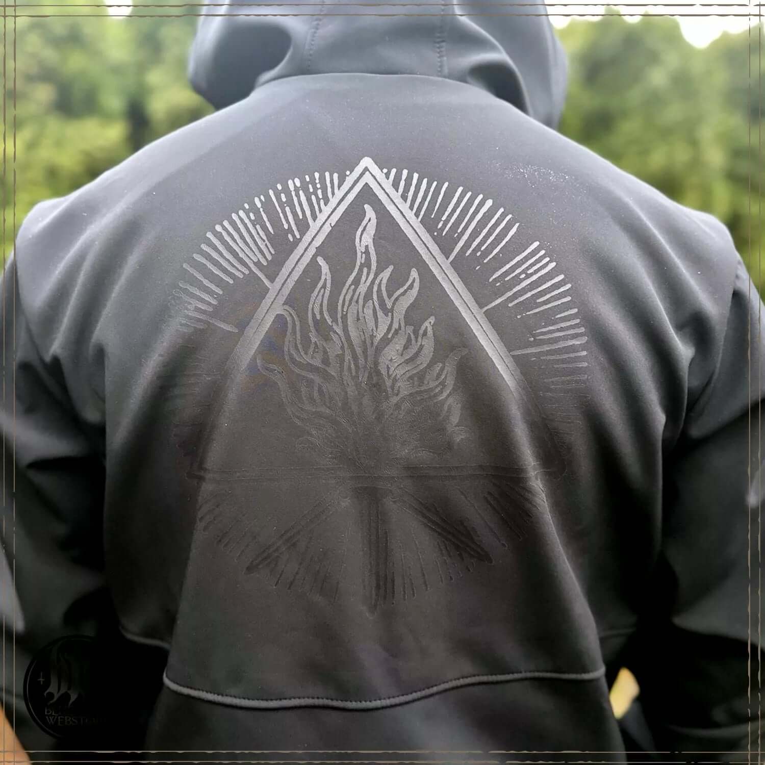 Back view of Behemoth 'Legions' Softshell Jacket with embossed Unholy Trinity symbol, black color, large hood, and minimal branding.