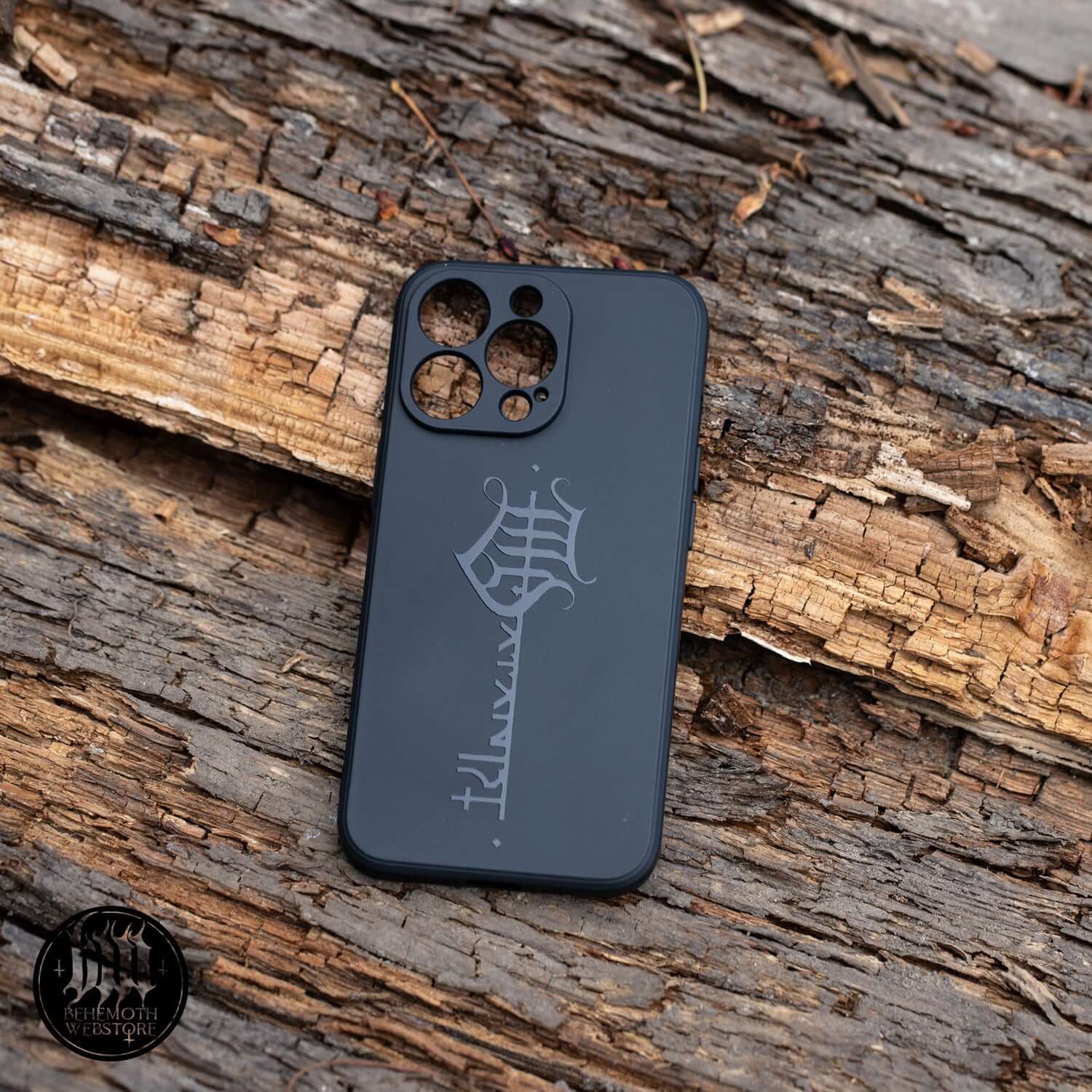 Behemoth 'The Satanist' silicone phone case with matte finish and Key Sigil design, black, on rustic wooden background.
