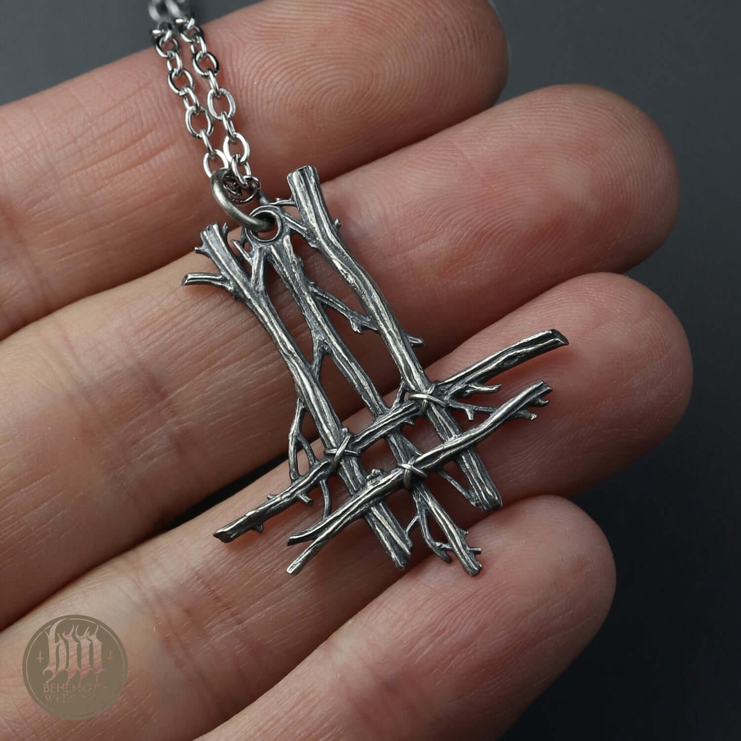 Behemoth 'Trivmviratvs' sterling silver pendant necklace on hand, featuring detailed hand-crafted design.