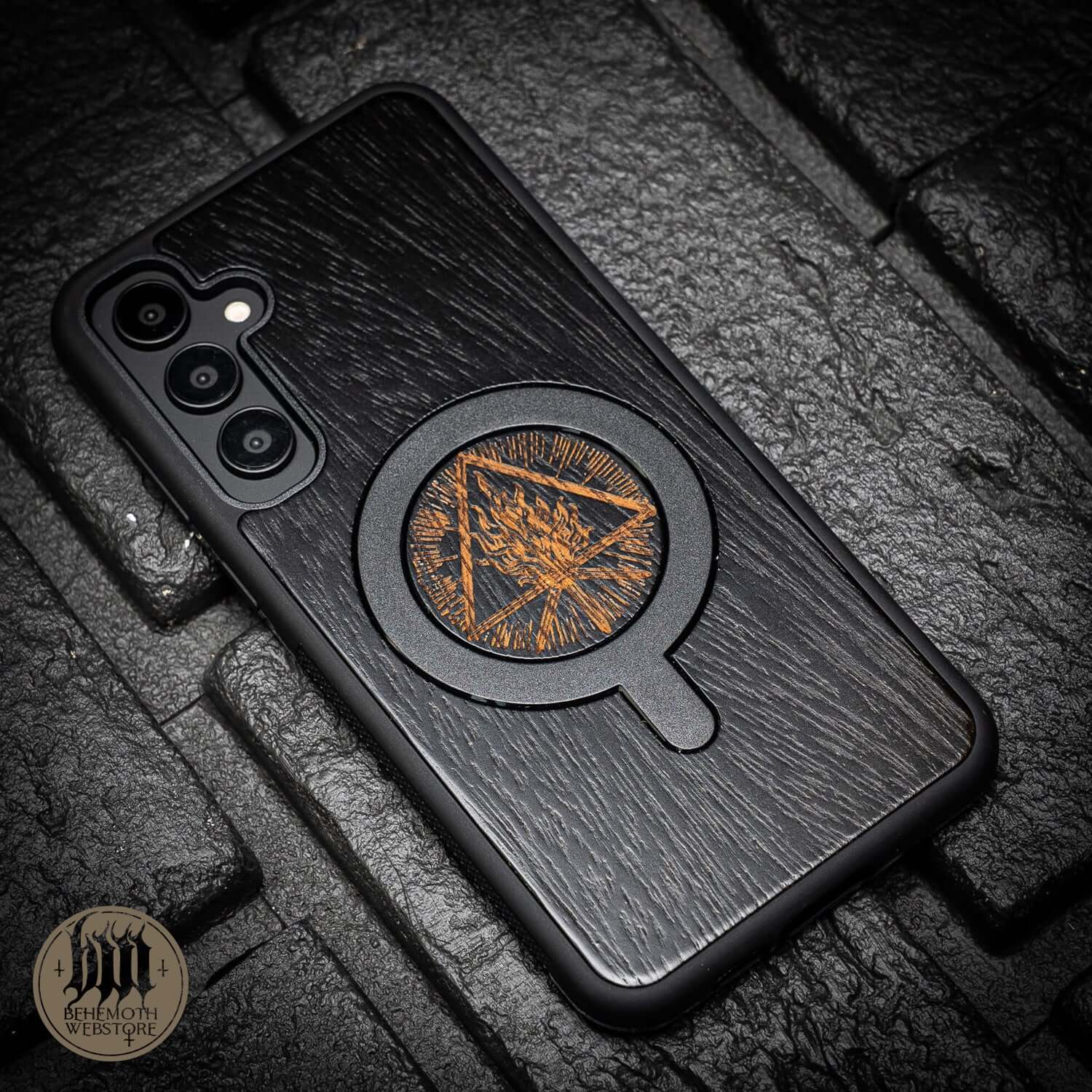 Behemoth black wooden MagSafe phone case with 'Thru Fire We Walk' design, featuring precision-crafted oak and silicone TPU.