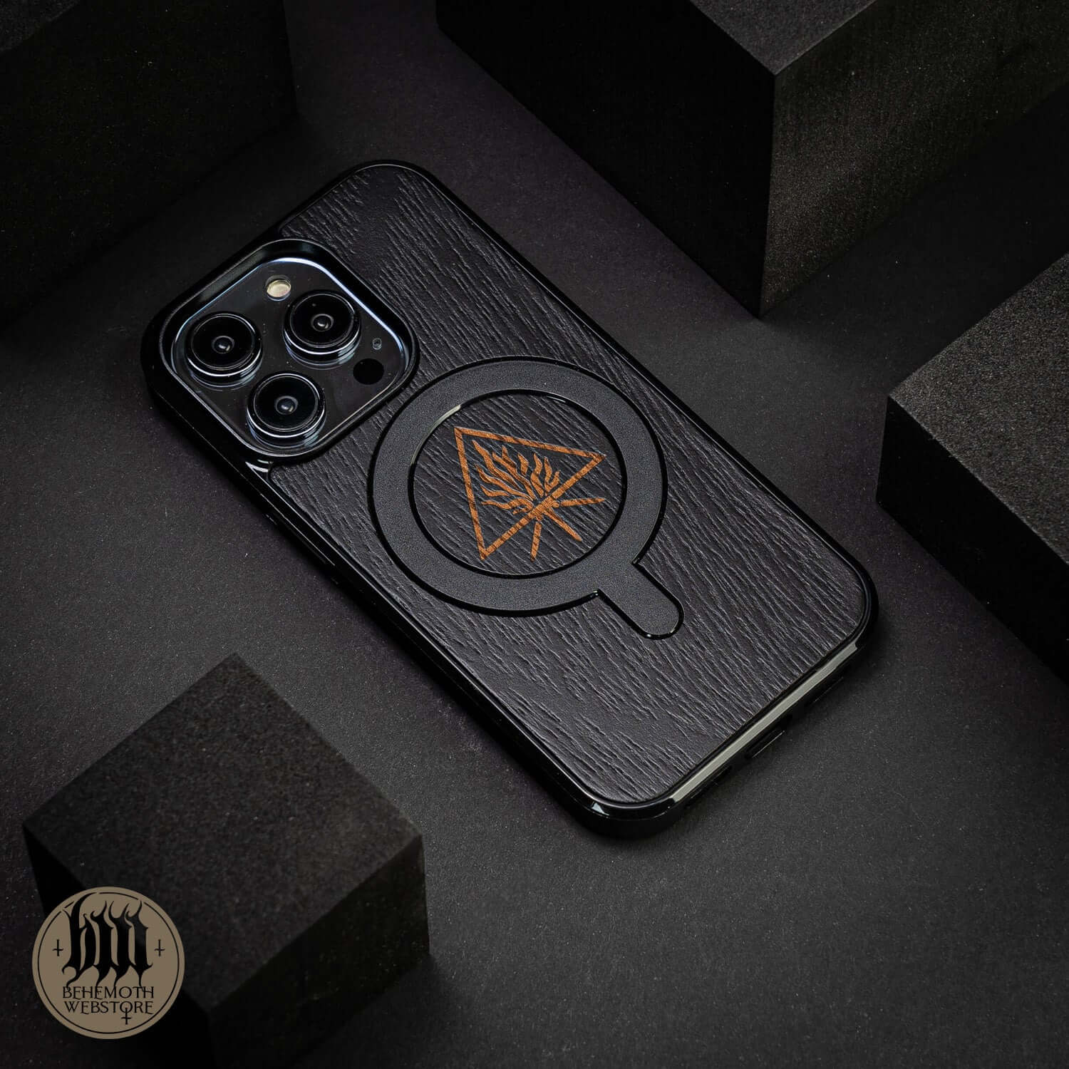 Behemoth 'The Unholy Trinity' black wooden oak MagSafe phone case with triangle design, handcrafted in Poland.