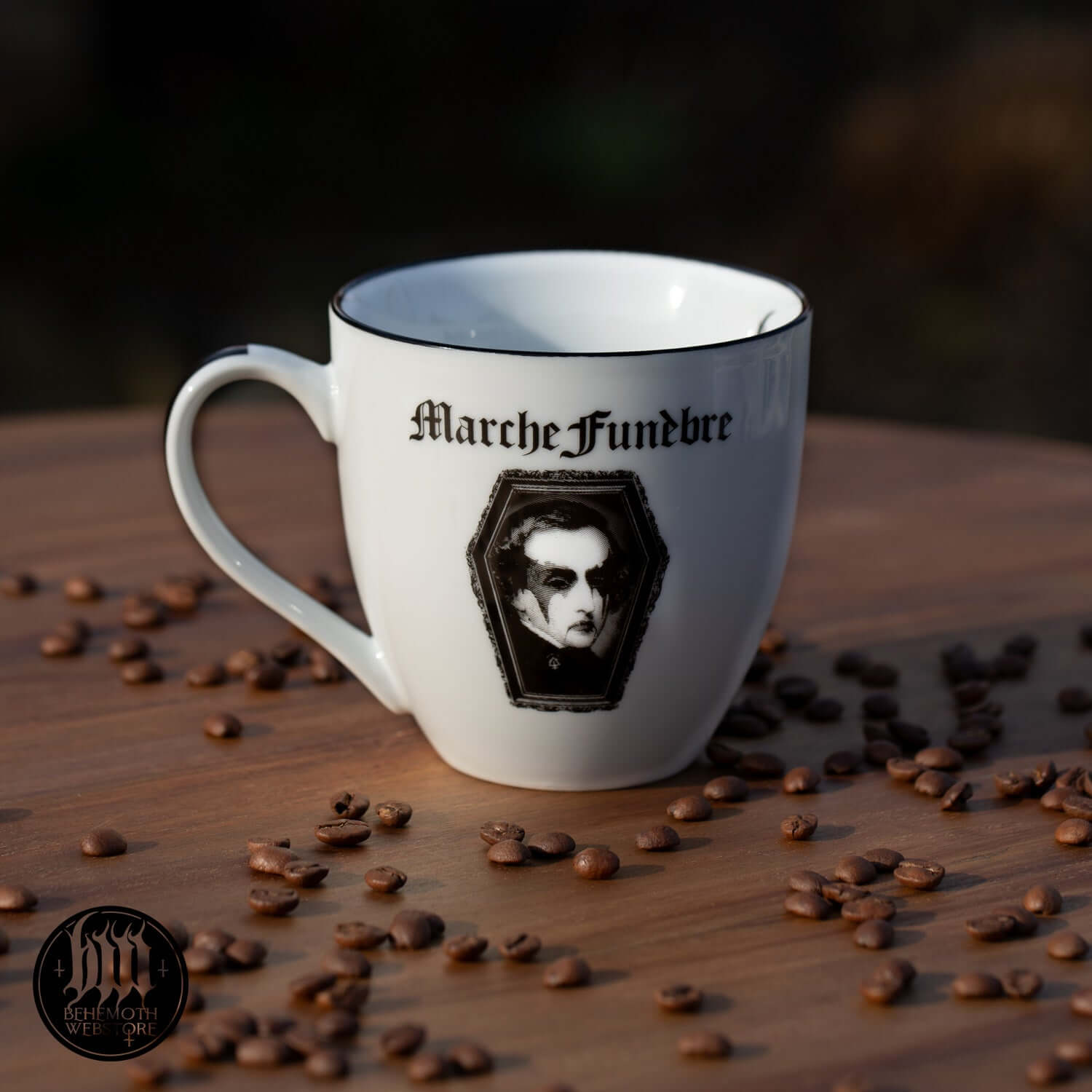 Behemoth 'Polonaise Satanique' mug featuring a dark design on a wooden table with coffee beans scattered around.
