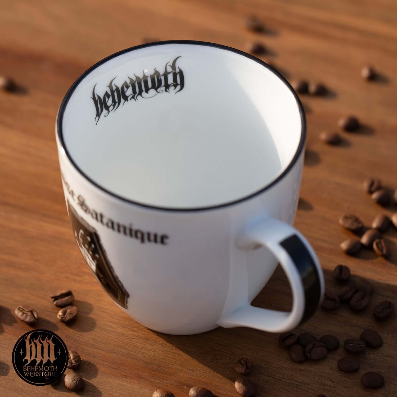 Behemoth 'Polonaise Satanique' coffee mug on wooden table with scattered coffee beans