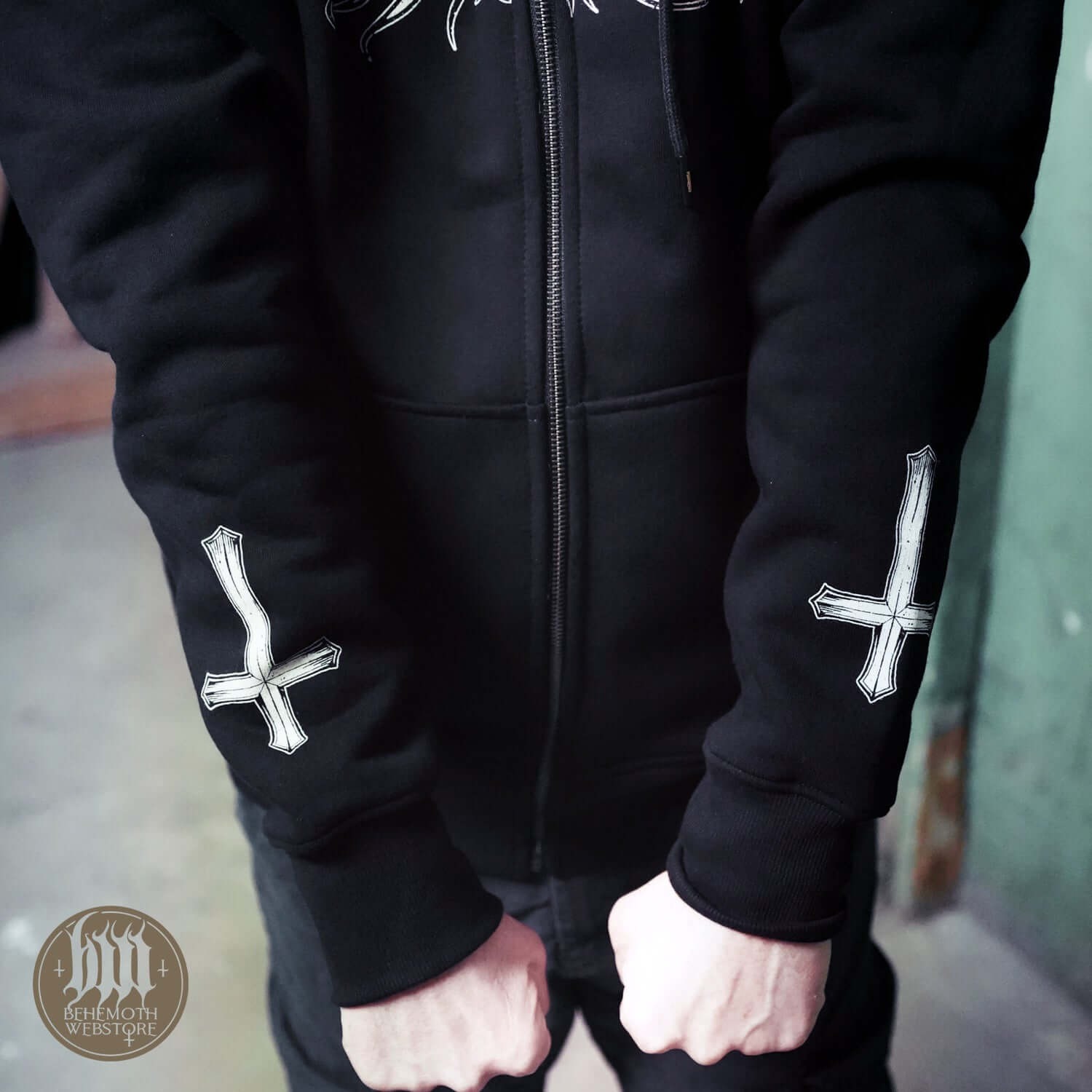 Person wearing Behemoth 'Republic Of The Unfaithful' hoodie with zip, featuring distinctive cross designs on the sleeves, supporting artistic freedom.