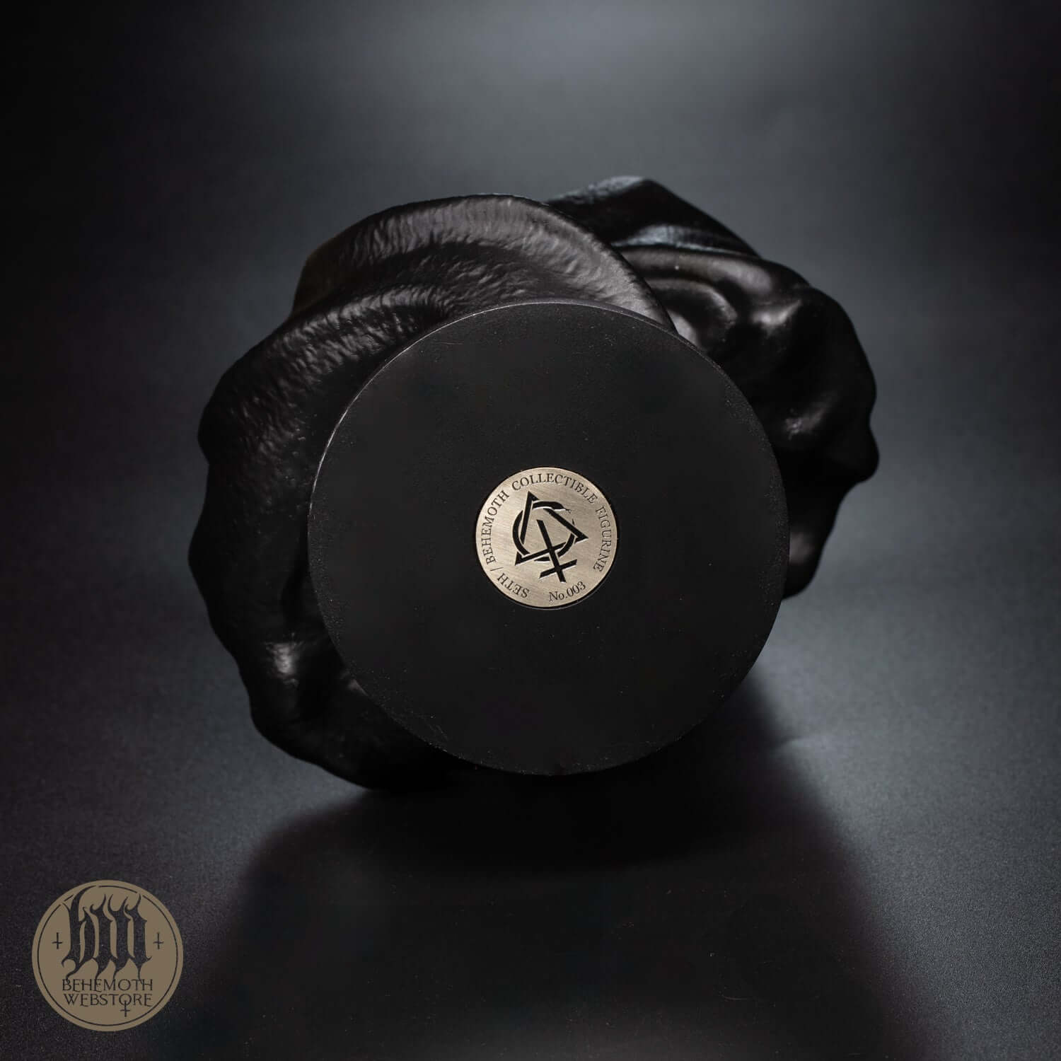 Base of 'Seth/Behemoth' collectible figurine showing numbered Contra metal coin for authenticity, polyurethane resin, hand-painted.