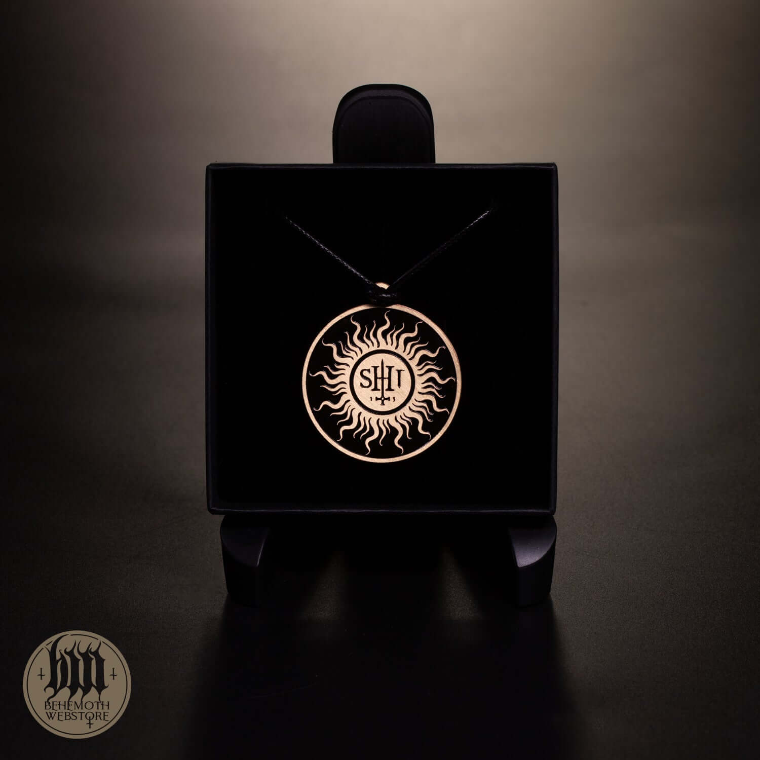 Behemoth 'TSOG' patinated brass necklace with strap on display, features intricate sun design, 4cm diameter, elegant packaging