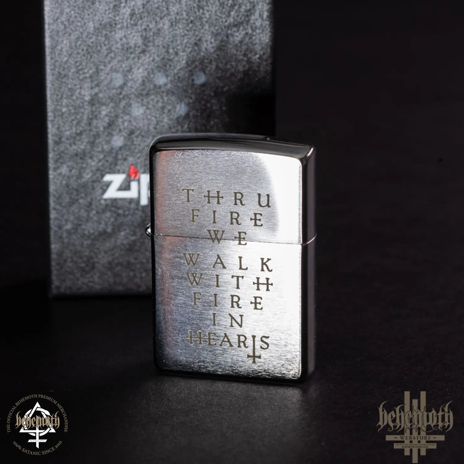 Un encendedor ZIPPO Behemoth con la leyenda 'Thru Fire We Walk'