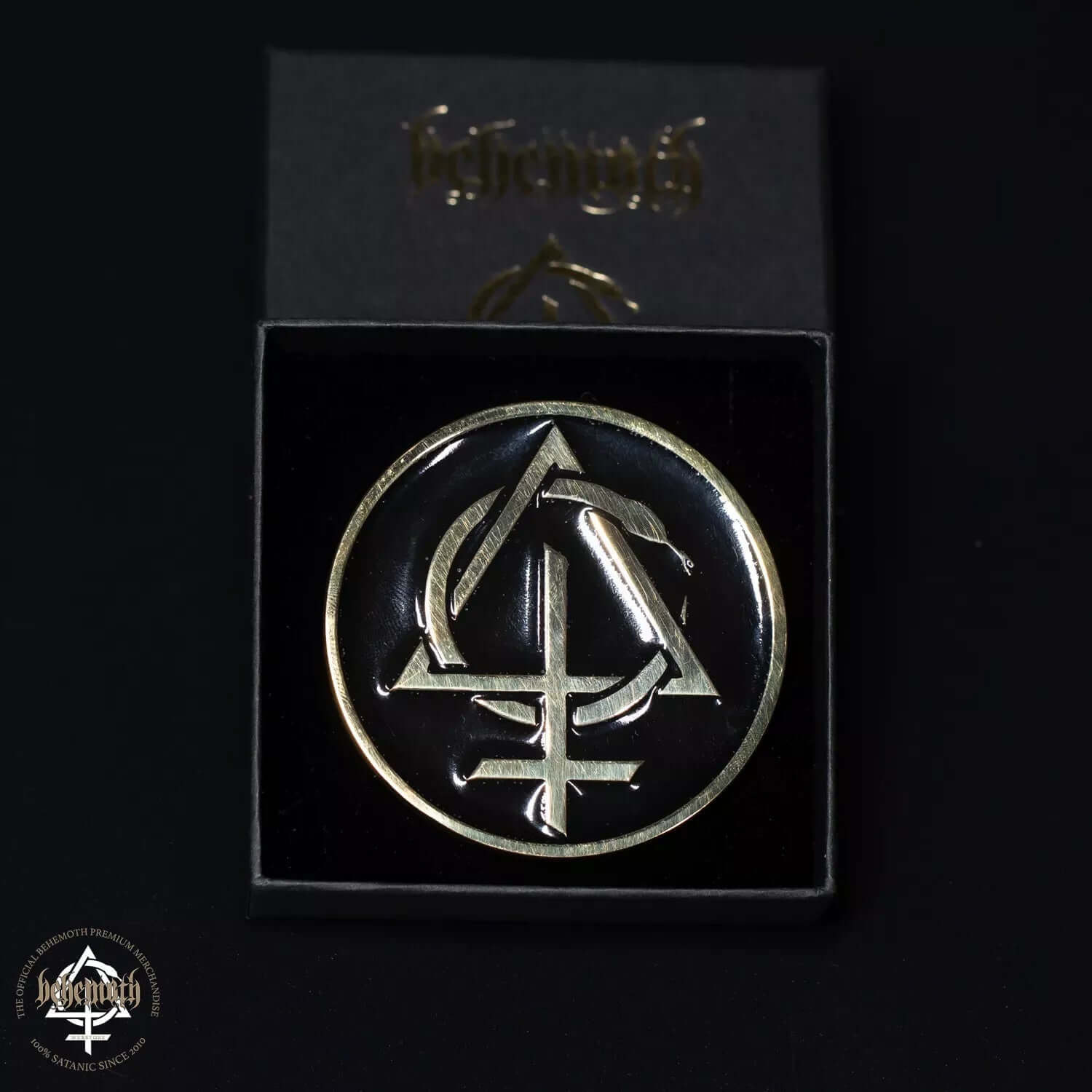 Behemoth 'Contra' belt buckle with brass sigil, black epoxy resin background, handmade in Poland, shown in presentation box.